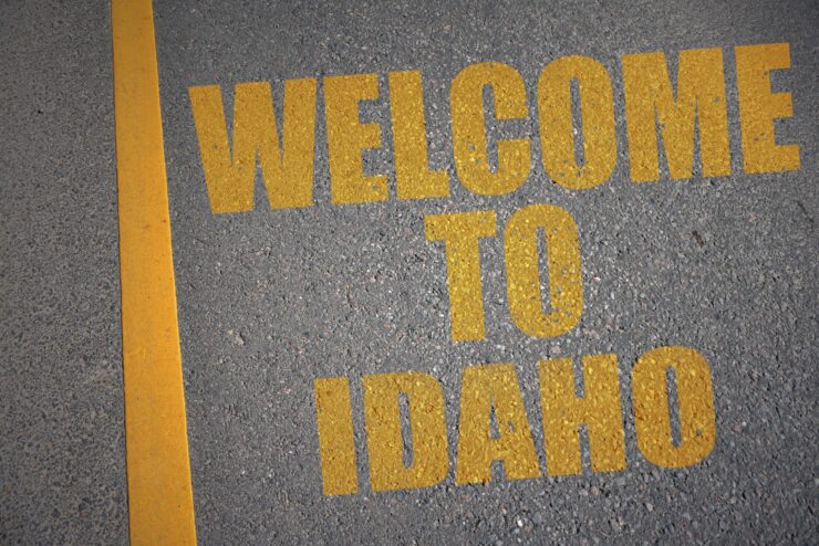 asphalt road with text welcome to idaho near yellow line.